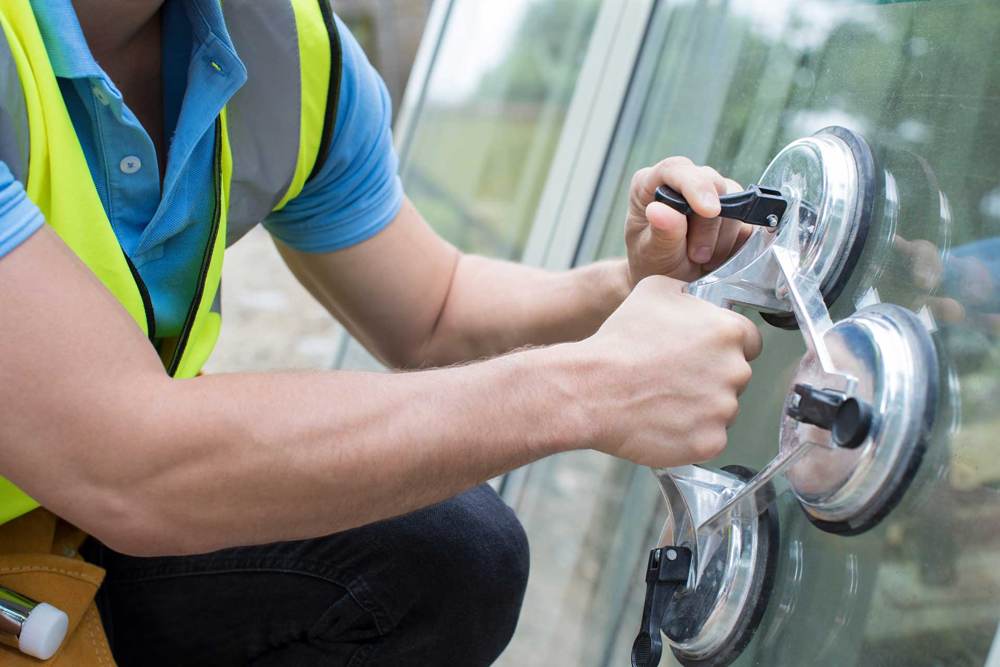 Installer placing impact glass with suction cups