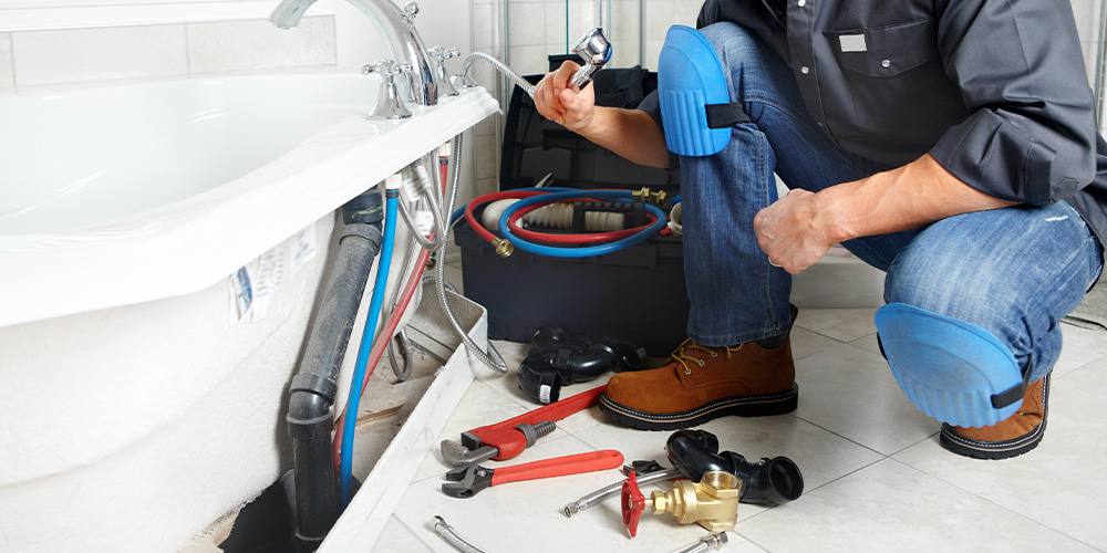 Plumber working on a bathtub installation