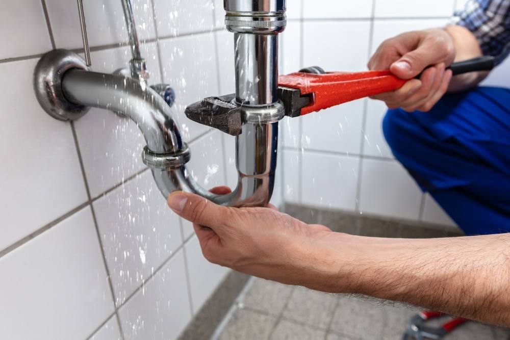 Plumber tightening a pipe fitting